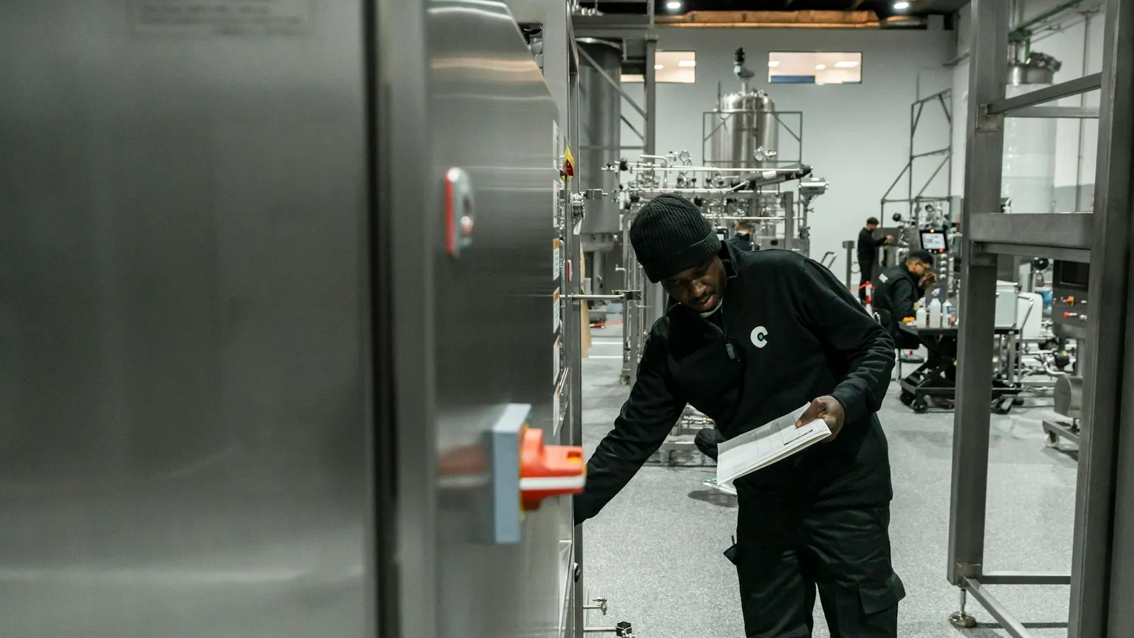 Engenheiro inspecionando equipamento em fábrica moderna, referência à verificação de emissões exigida pelo SBCE