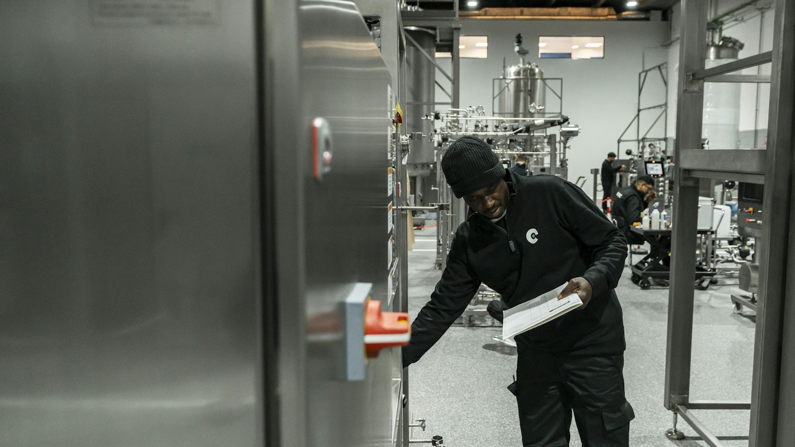Engenheiro inspecionando equipamento em fábrica moderna, referência à verificação de emissões exigida pelo SBCE